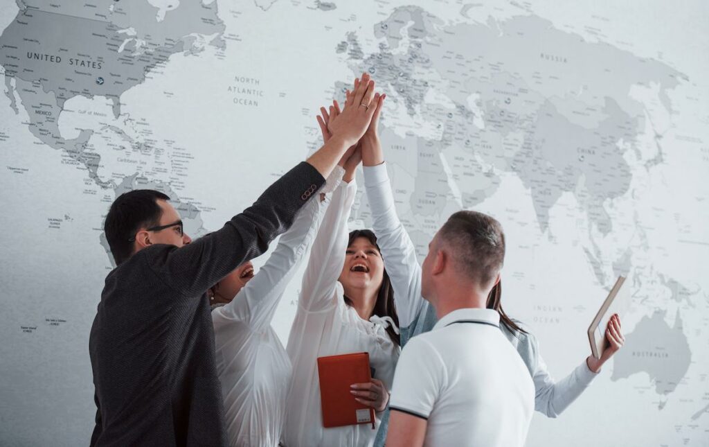 A group of people high-fiving near a map of Antigua and Barbuda visa free countries