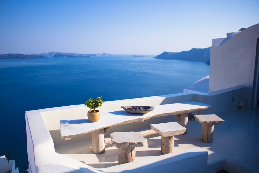 A stone table and chairs overlooking the ocean in Greece.