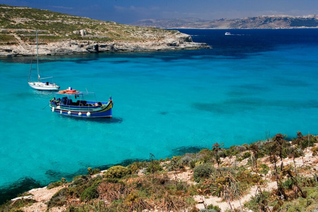 A boat in the crystal clear water of Malta, a citizenship by investment option.