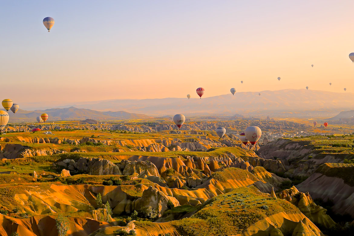 A photo taken in turkey, featuring hot air balloons over a beautiful valley.