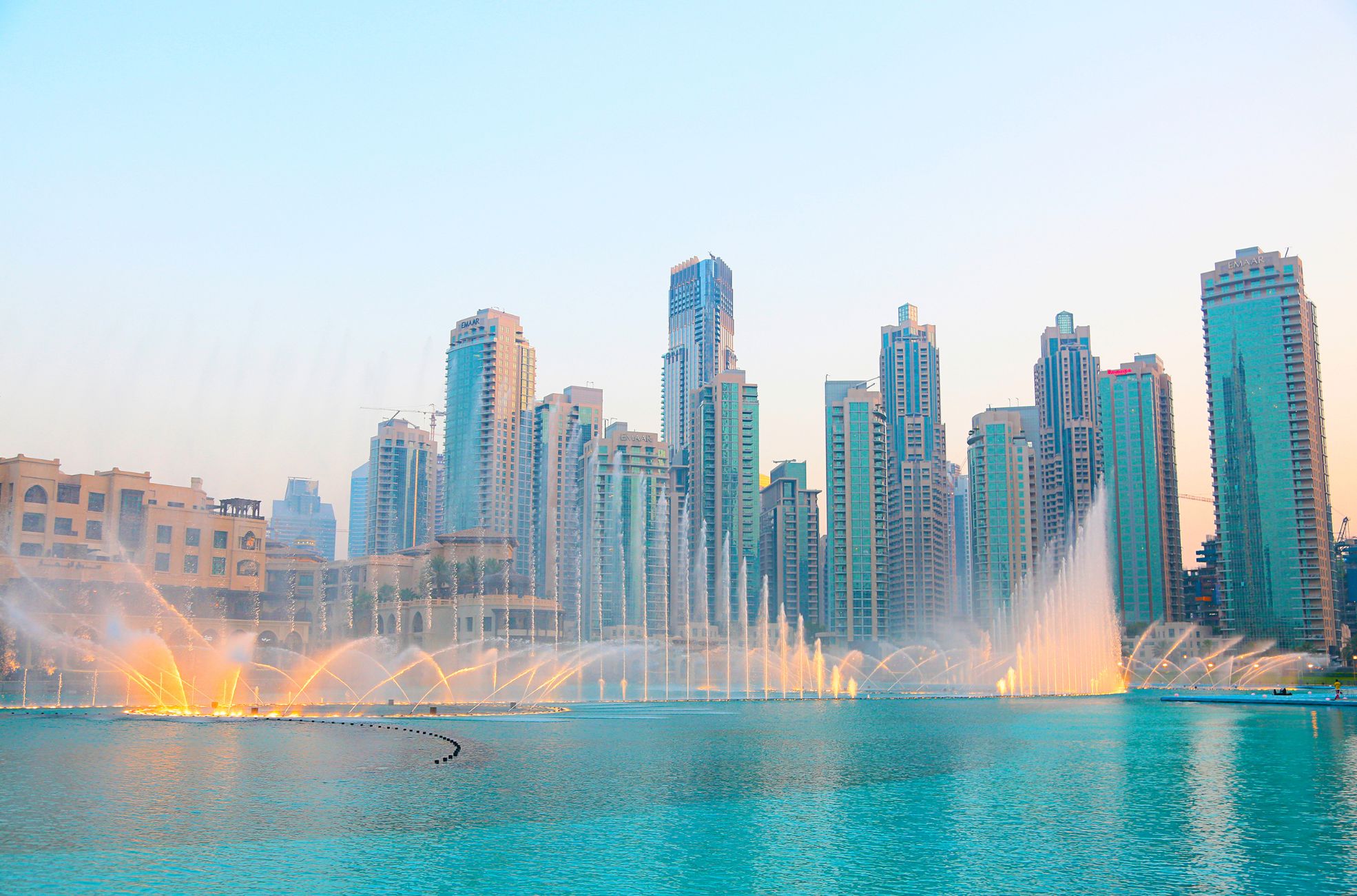 A picture of the fountains in the UAE, with large buildings in the background.